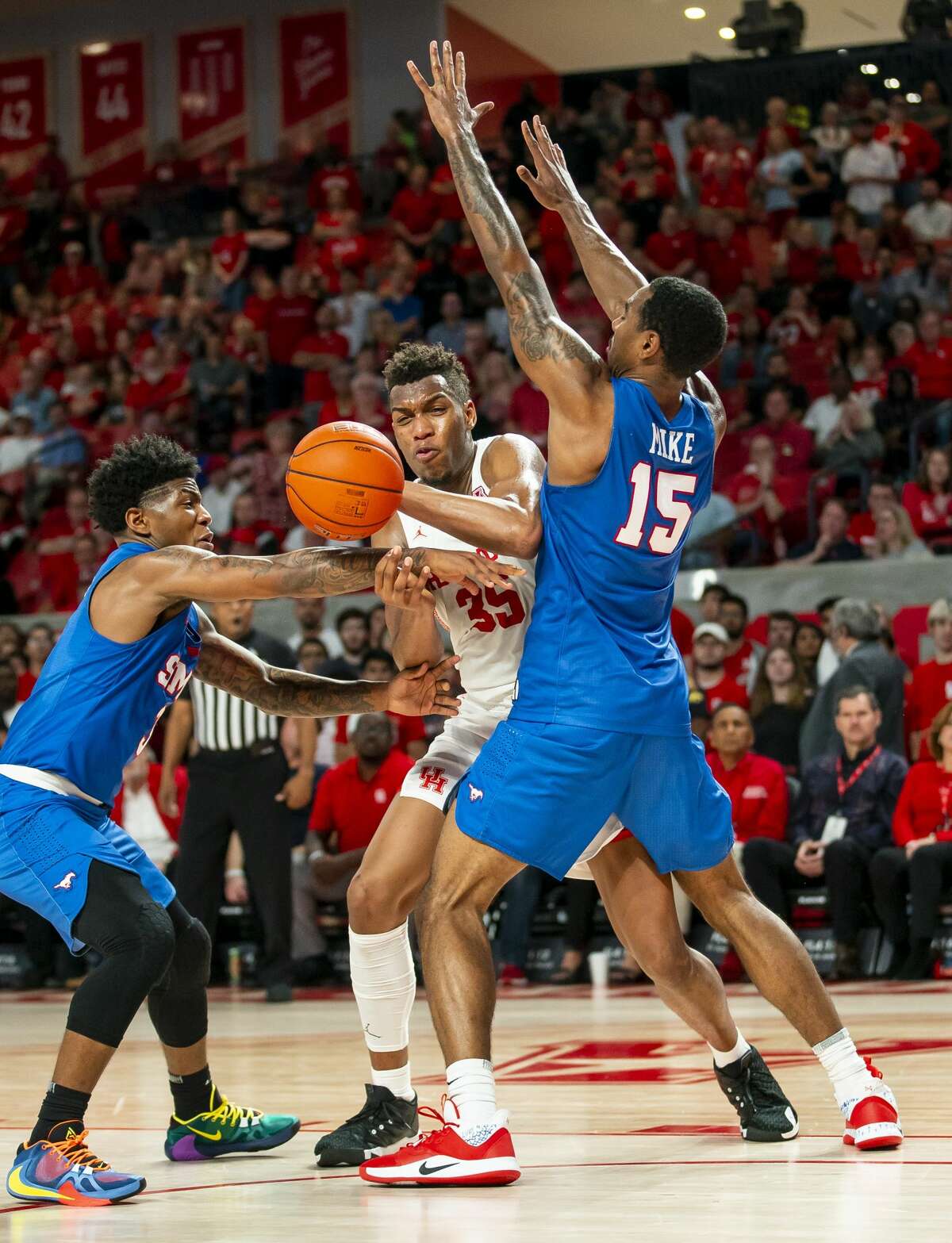 Houston Cougars forward Fabian White Jr. (35) tries to shoot through the defense of Southern Methodist Mustangs guard Kendric Davis (3) and forward Isiaha Mike (15) during the second half of the Cougars' game against the Mustangs at the Fertitta Center in Houston, Wednesday, Jan. 15, 2020.