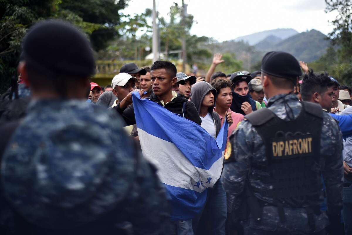 Honduran migrants stand in front of a line of Guatemalan policemen after going through a police fence at the Agua Caliente border crossing from Honduras, near Esquipulas, Chiquimula departament, Guatemala, on January 16, 2020, on their way to the US. - Hundreds of people in the vanguard of a new migrant caravan from Honduras forced their way across the border with Guatemala on Wednesday, intent on reaching the United States. (Photo by Johan ORDONEZ / AFP) (Photo by JOHAN ORDONEZ/AFP via Getty Images)