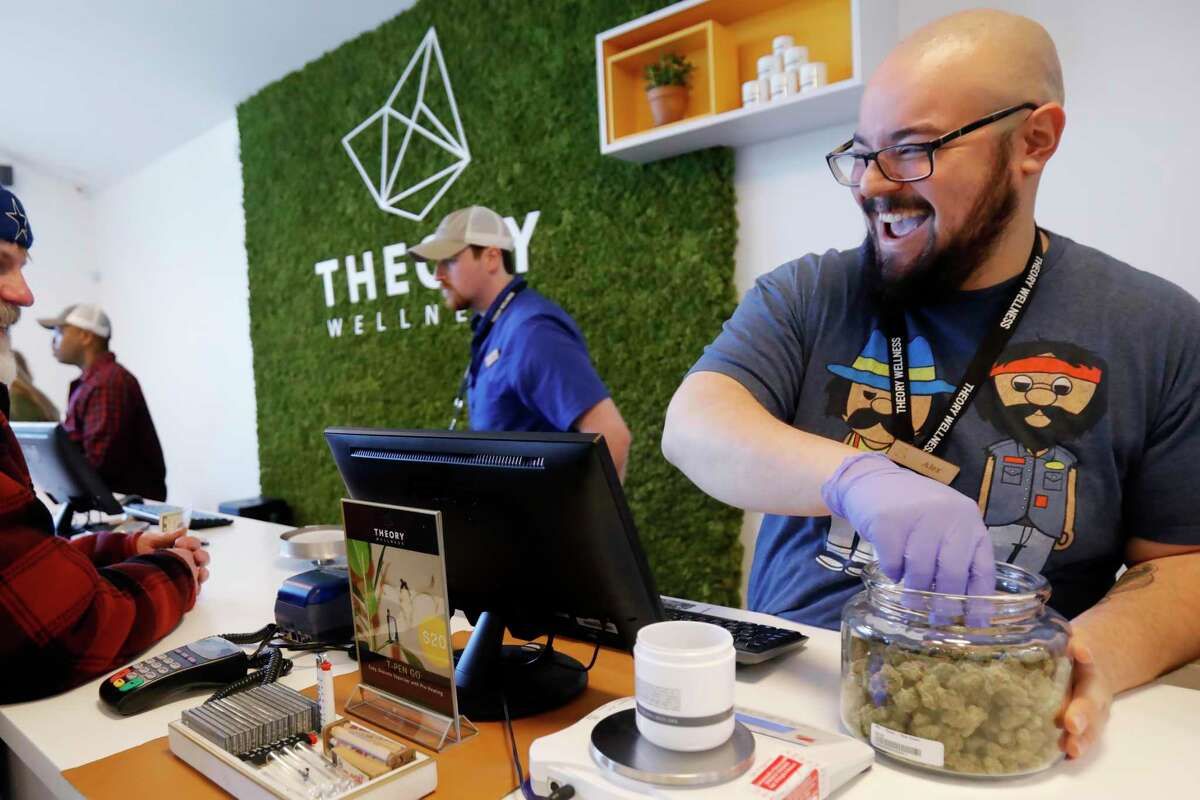 Alex Premoli makes the first sale to a customer on the opening day of recreational marijuana sales at Theory Wellness in Great Barrington, Mass., Friday, January 11, 2019. Theory is the first dispensary in the Berkshires to open its doors for recreational marijuana sales and the opening makes Theory the 6th dispensary of its kind in the state. (Stephanie Zollshan/The Berkshire Eagle via AP)