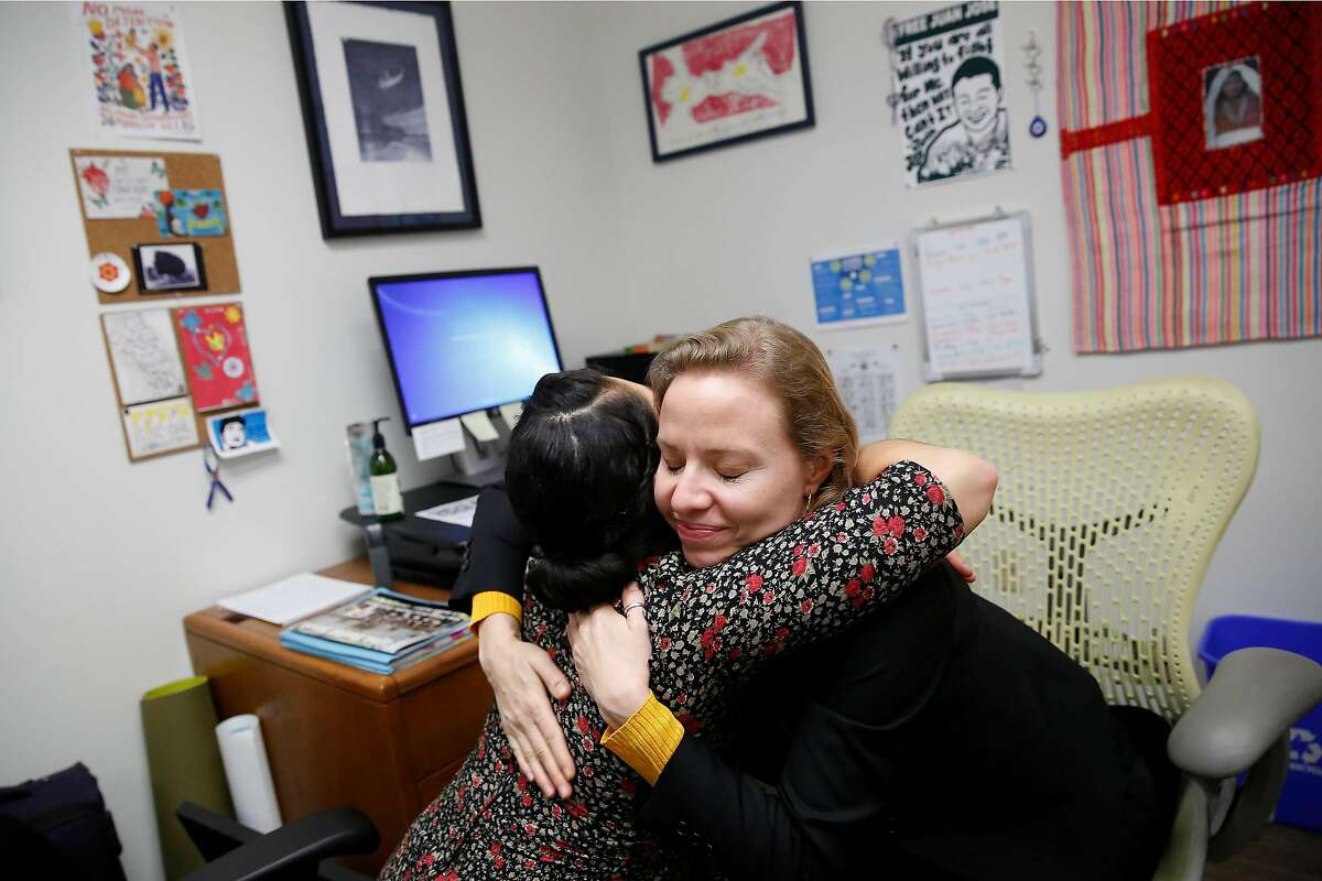 Kelly Engel Wells (right), deputy public defender, and Edie Castellon (left), immigration social worker Office of the Public Defender, hug during an emotional moment while discussing clients’ cases in Wells’ office at the Office of the Public Defender on Friday, January 17, 2020 in San Francisco, Calif.