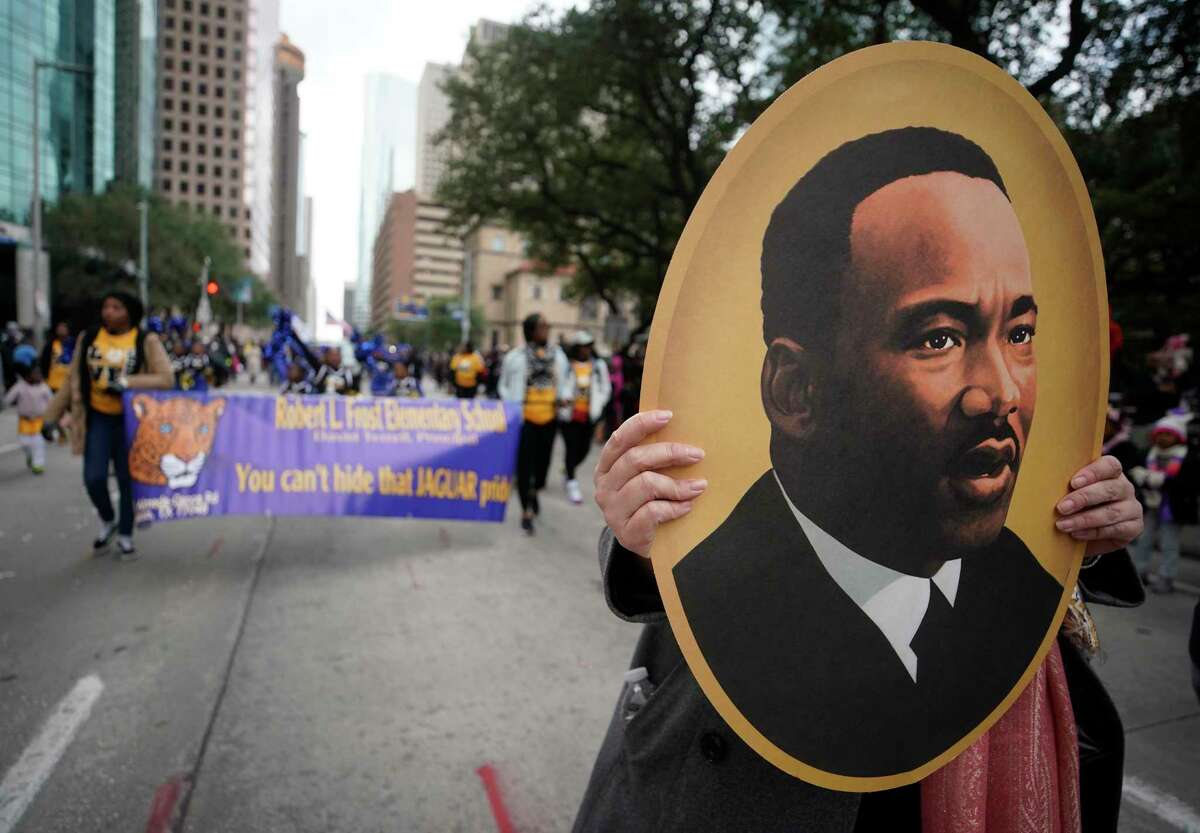 A person marches with a portrait of Martin Luther King, Jr. during the Black Heritage Society's 41st Annual Original MLK, Jr. Day Parade Monday, January 21, 2019 in Houston.