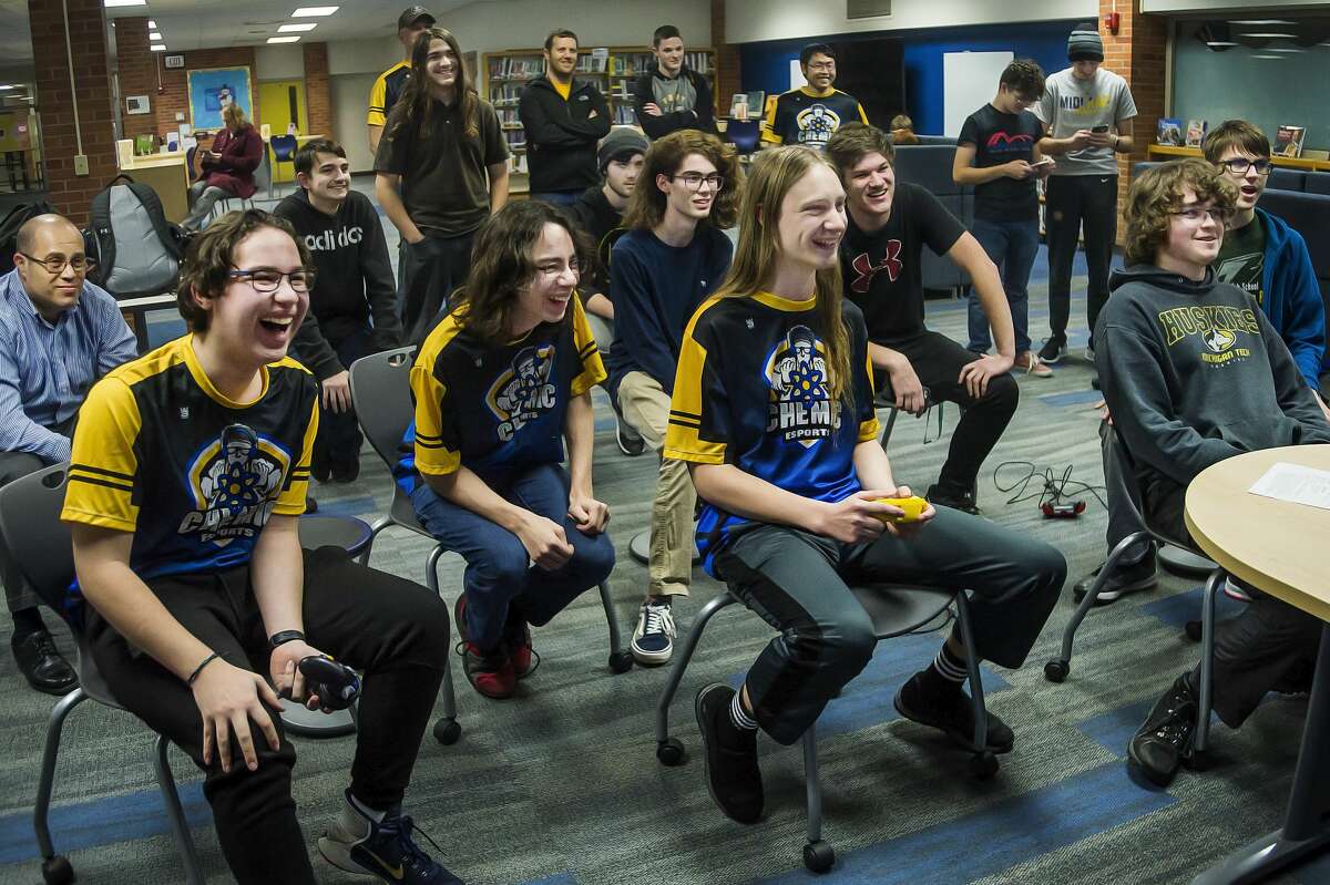 Midland High's Ryan Rinearson, third from left, plays a game of Super Smash Bros. against Dow High's Nathan Seidel, right, as other players, parents and coaches watch during the two schools' esports meet Friday, Jan. 17, 2020 at Midland High. (Katy Kildee/kkildee@mdn.net)