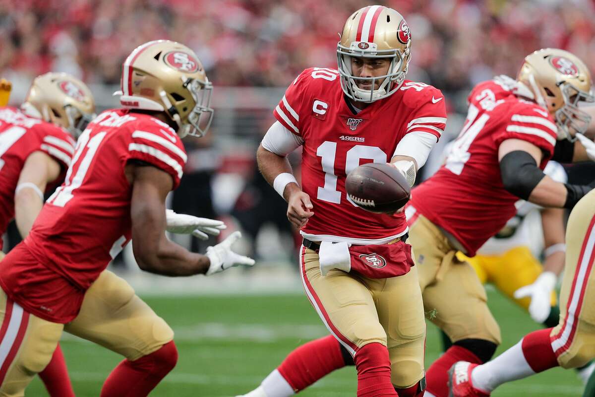 San Francisco 49ers’ Jimmy Garoppolo hands off to Raheem Mostert in the first quarter during the NFC Championship game between the San Francisco 49ers and the Green Bay Packers at Levi’s Stadium on Sunday, Jan. 19, 2020 in Santa Clara, Calif.