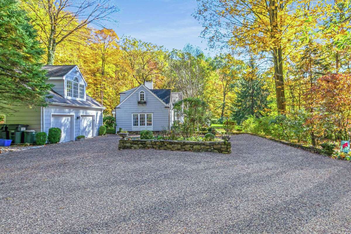 Travel down a long circular driveway to the property that contains the nine-room, 2,944-square-foot house and detached two-car garage with living space above.