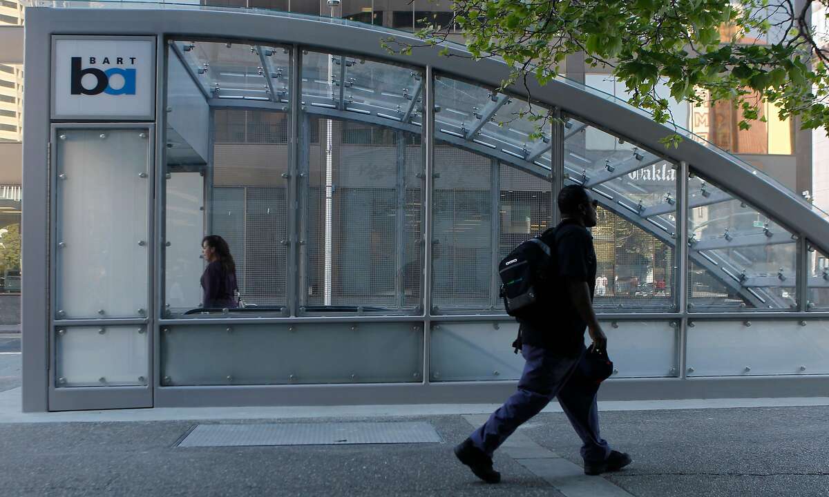Commuters walk past the new canopy over the 19th Street Bart Station entrance at 20th and Broadway streets in Oakland, Calif. is opened to the public Friday, March 6, 2015.