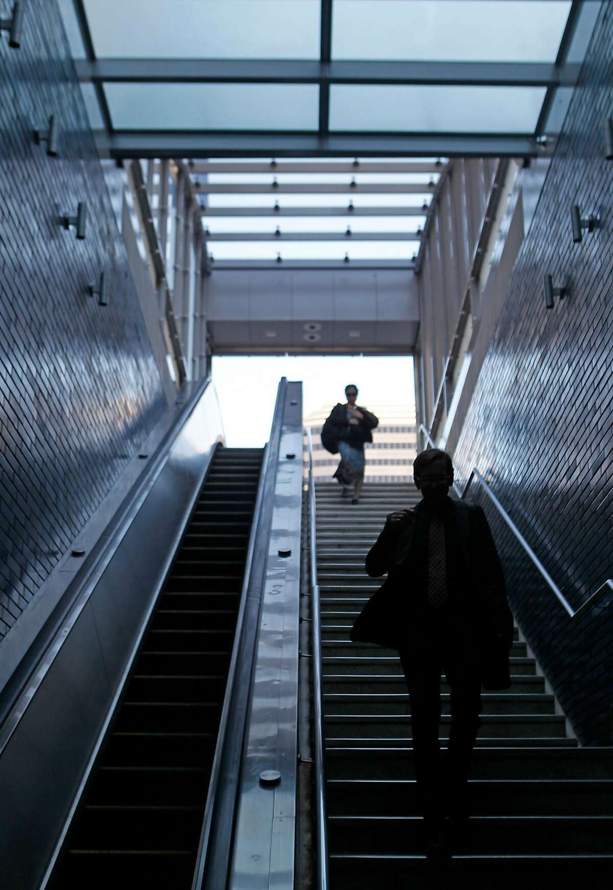 Commuters enter 19th Street BART through the new canopy over the entrance at 20th and Broadway streets in Oakland, Calif. is opened to the public Friday, March 6, 2015.