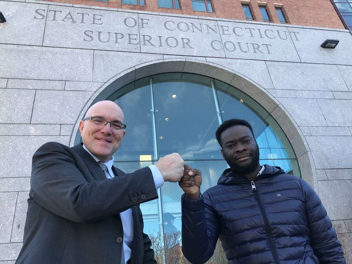 Criminal Defense Attorney Allan Friedman and Emmanuel Mong fist bump in celebration of larceny and conspiracy charges being thrown out against Mong at the Stamford courthouse Tuesday morning.