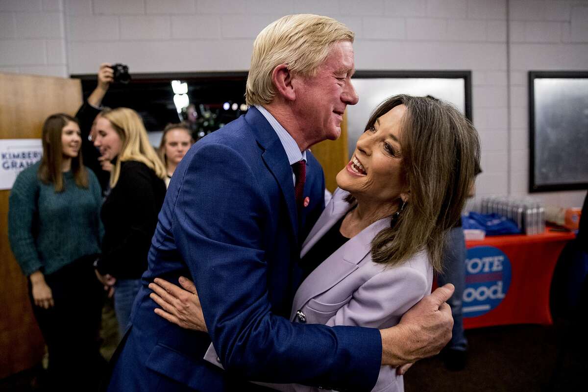 Republican presidential candidate former Massachusetts Gov. Bill Weld, left, and Democratic presidential candidate Marianne Williamson, right, greet each other at a Faith, Politics and the Common Good Forum at Franklin Jr. High School, Thursday, Jan. 9, 2020, in Des Moines, Iowa.