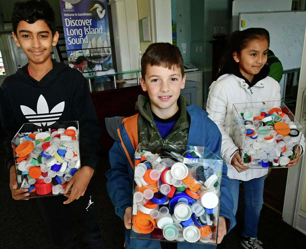 Sixth graders from Dolan Middle School Jayden Howard, Tyler O'Grady and Litzi Najera display some of the bottle caps they collected learn about how plastics enter the ecosystem in conjunction with the The One Million Bottle Cap Challenge Friday, November 1, 2019, at the Soundwaters headquarters at Cove Island Park in Stamford, Conn. SoundWaters has launched the initiative with Stamford Public Schools to have students remove one million bottle caps before they reach the Sound during the school year.
