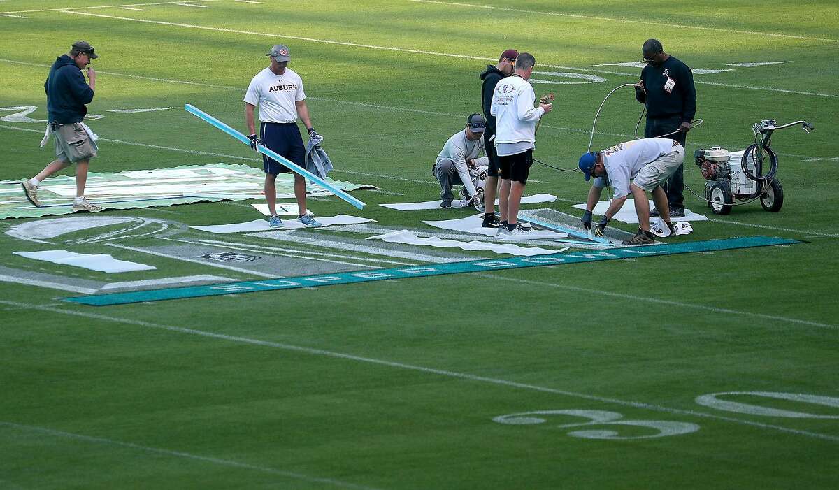 Workers paint the field at Hard Rock Stadium Stadium in Miami Gardens, Fla., on Tuesday, Jan. 21, 2020, in anticipation of Super Bowl LIV, featuring the Kansas City Chiefs against the San Francisco 49ers on February 2, 2020. (Mike Stocker/Sun Sentinel/TNS)