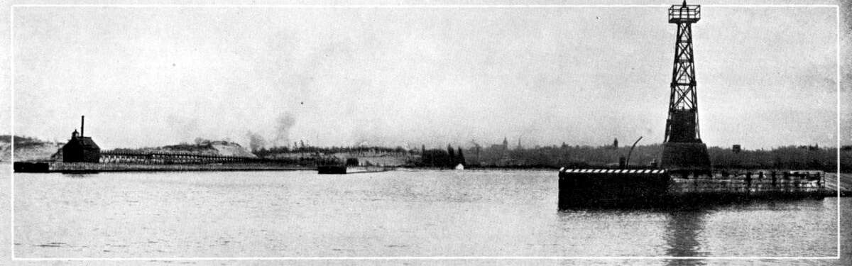 The entrance to the Manistee Harbor looked much different in the 1890s with the lighthouse that was located there at the time.
