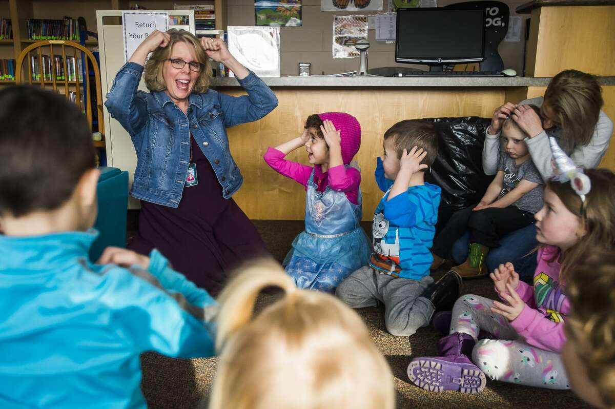 Diana Ball, librarian at St. Brigid Catholic School, recites a rhyme with a group of children during a preschool story hour Wednesday, Jan. 22, 2020 at the school. (Katy Kildee/kkildee@mdn.net)
