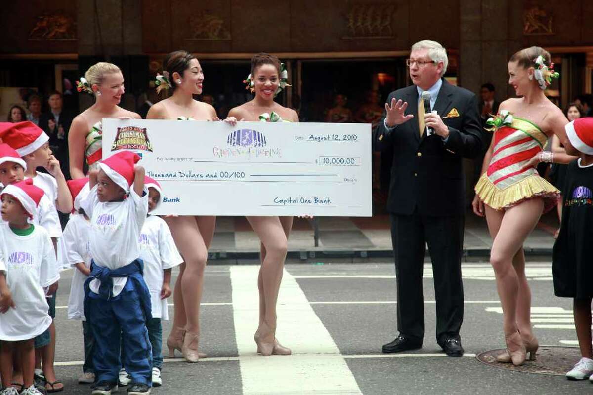 NEW YORK - AUGUST 12: Capital One Bank of Manhattan market president James Covington (R) presents a $10,000 check towards the Garden of Dream Foundation during the 2010 Radio City Christmas Spectacular Kick-Off at Radio City Music Hall on August 12, 2010 in New York City. (Photo by Astrid Stawiarz/Getty Images) *** Local Caption *** James Covington