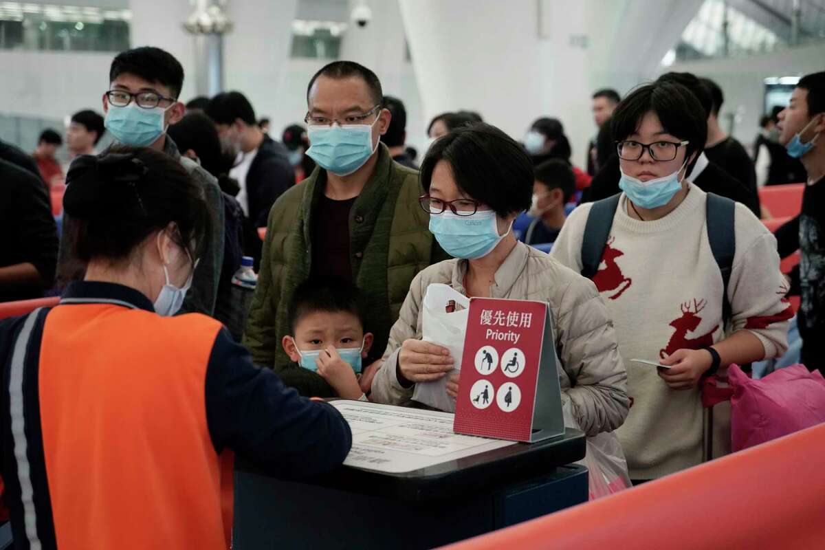 Passengers wear masks to prevent an outbreak of a new coronavirus in the high speed train station, in Hong Kong, Wednesday, Jan. 22, 2020. The first case of coronavirus in Macao was confirmed on Wednesday, according to state broadcaster CCTV. The infected person, a 52-year-old woman, was a traveller from Wuhan.