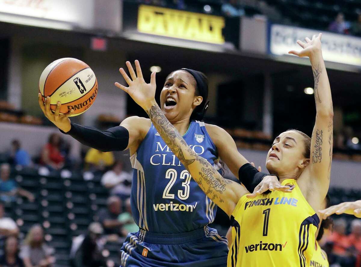 Minnesota Lynx's Maya Moore, left, shoots against Indiana Fever's Jazmon Gwathmey during the first half of a WNBA basketball game in Indianapolis on Aug. 30, 2017.