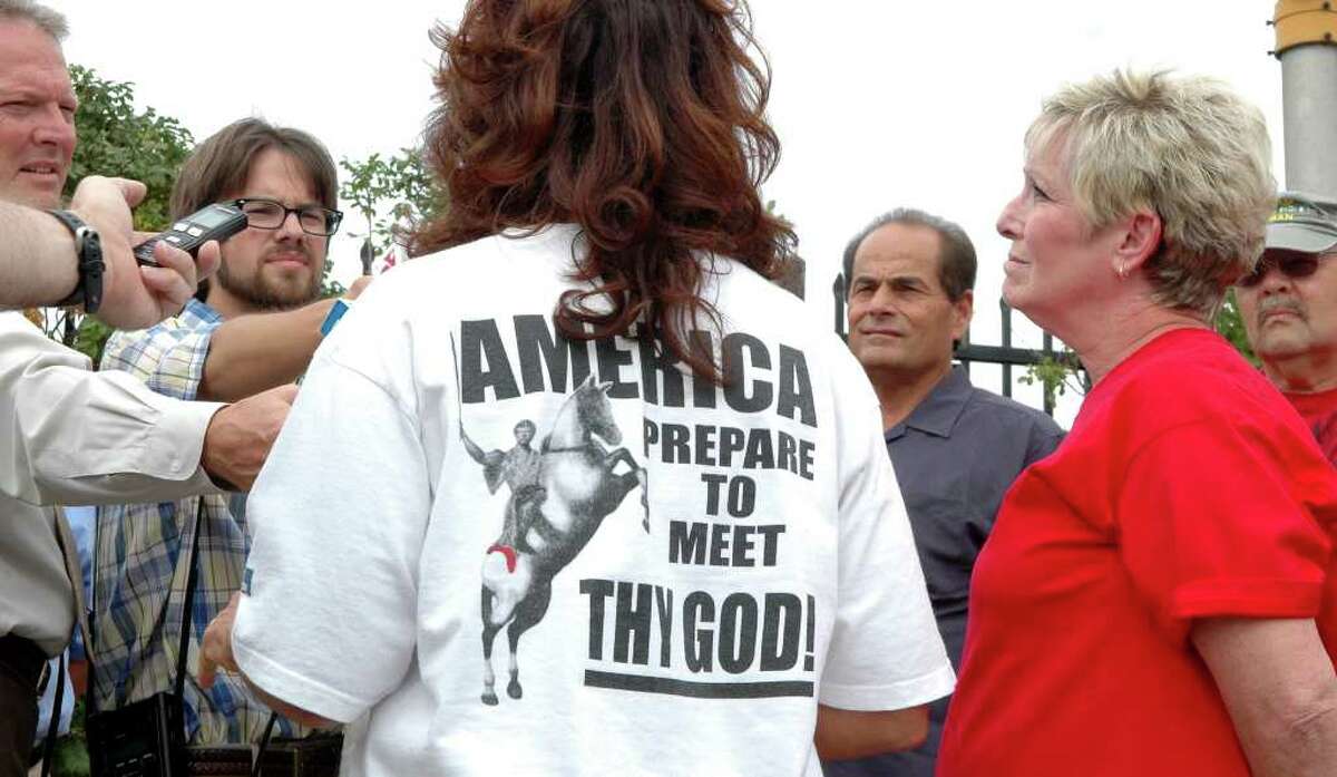 Marilyn Carroll, back to camera, addresses the media as Christian supporters of the group Operation Save America attend a news conference near the Bridgeport Islamic Society on Fairfield Ave., in Bridgeport, Conn. on Friday August 13, 2010. Supporters, Jim Loomer, Pam Bonaiuto and Ron Jersey Sr. stand to the right of Carroll.
