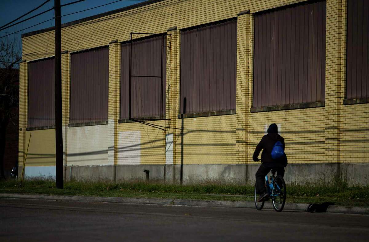 A cyclist passes a shuttered warehouse along Canal Street just east of Burnet Elementary School in Houston's east end, Thursday, Dec. 19, 2019. Both residents and developers in Houston’s East End are fighting to keep the Houston Housing Authority from bringing some 1,400 new apartments -many targeted to lower income Houstonians - to their neighborhood. The area, they say, is already flush with affordable housing and the new projects will remove valuable property from the area’s Tax Increment Reinvestment Zone, which uses property tax dollars for public improvements. Moreover, they say, developers will choose other neighborhoods to invest in or cancel projects they were planning in the East End.