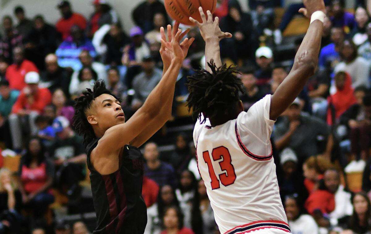 Summer Creek sophomore guard Jaleen Goodman, left, skies for a shot over Atascocita's Justin Collins (13) in the 2nd quarter of their District 22-6A matchup at Atascocita High School on Friday, Jan. 3, 2020.