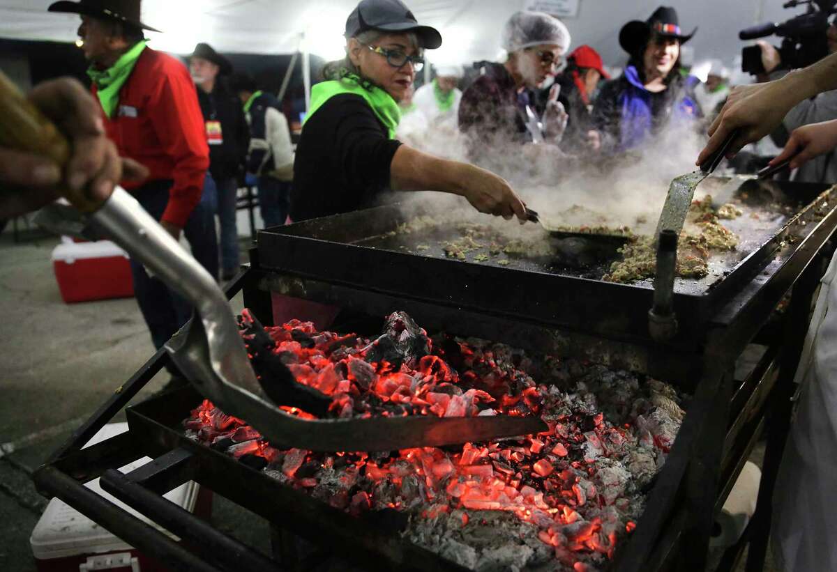 Hot coals are added to a grill where tacos are prepared at the 42nd annual Cowboy Breakfast at Cowboys Dancehall.