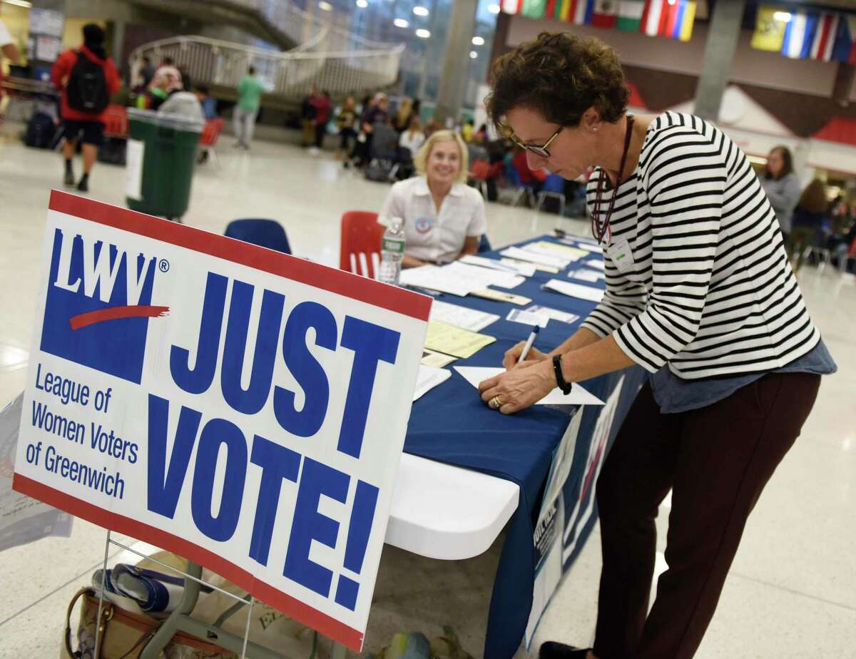 League of Women Voters of Greenwich voter service committee member Cathy Steel works at the LWV voting sign-up station at Greenwich High School in Greenwich, Conn. Tuesday, Sept. 25, 2018. The LWV set up a stand in the student center during the lunch periods in an nonpartisan effort to register eligible students to vote in the upcoming election.