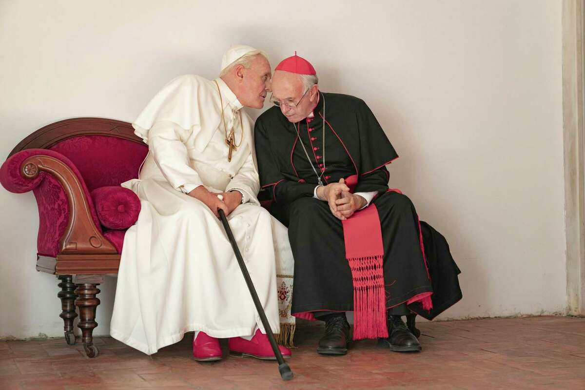 This image released by Netflix shows Jonathan Pryce as Cardinal Bergoglio, right, and Anthony Hopkins as Pope Benedict in a scene from "The Two Popes." The film is nominated for a Golden Globe for best motion picture drama.