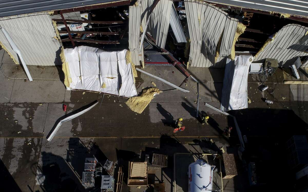 Houston Fire Department firefighters make their way through debris near the site of an explosion at Watson Grinding and Manufacturing on Friday, Jan. 24, 2020. Two people have been reported dead by officials.
