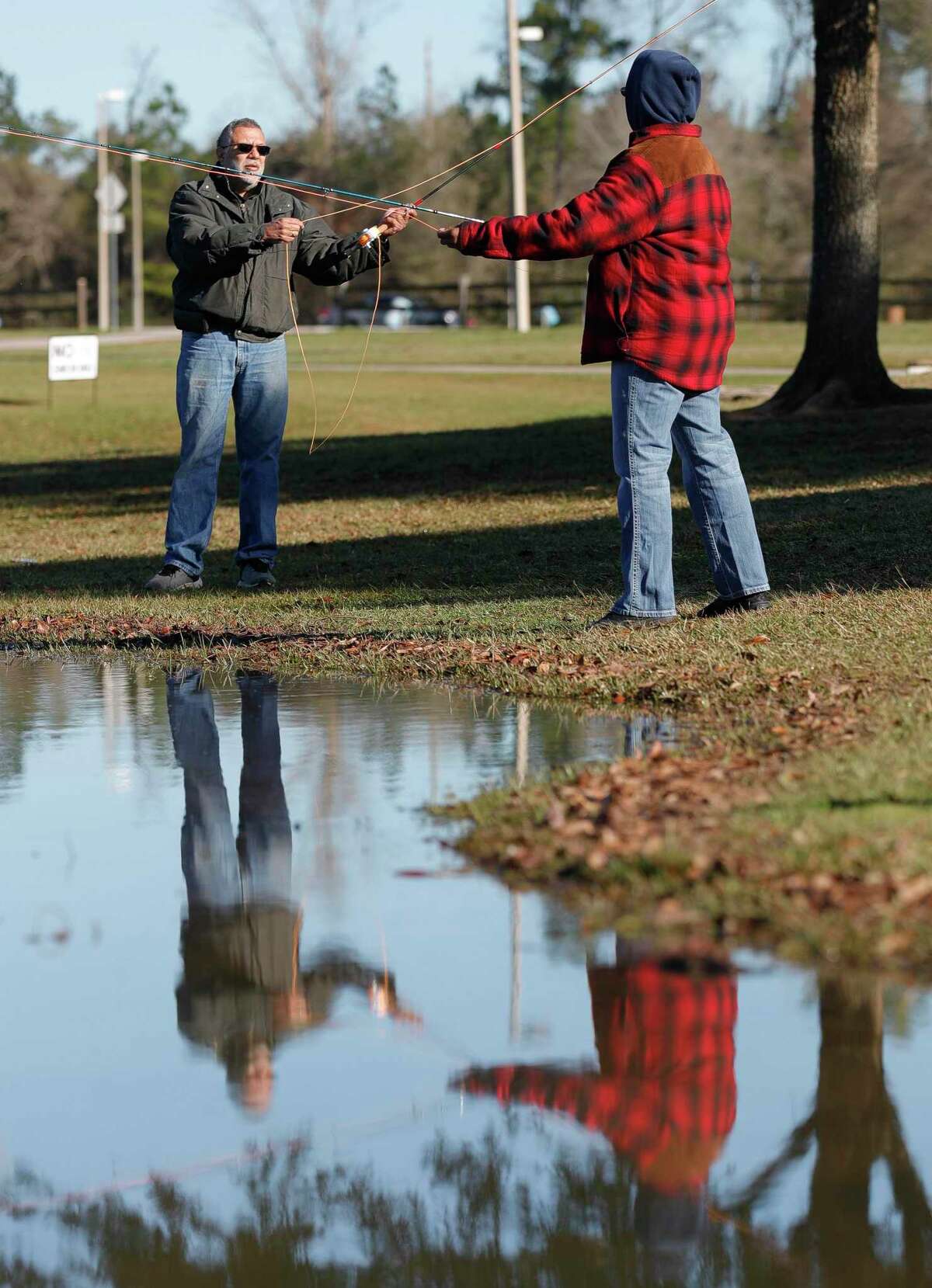 Army veteran Alan Corder, center, helps fellow Army veteran Carolyn Rhodes learn to fly fish as members of the Conroe Fly Fishers met to fish at Carl Barton, Jr. Park, Thursday, Jan. 23, 2020, in Conroe. The organization mets twice a month and is a part of the national nonprofit, Project Healing Waters Fly Fishing, which helps 8,300 disabled veterans nationwide with various treatments.