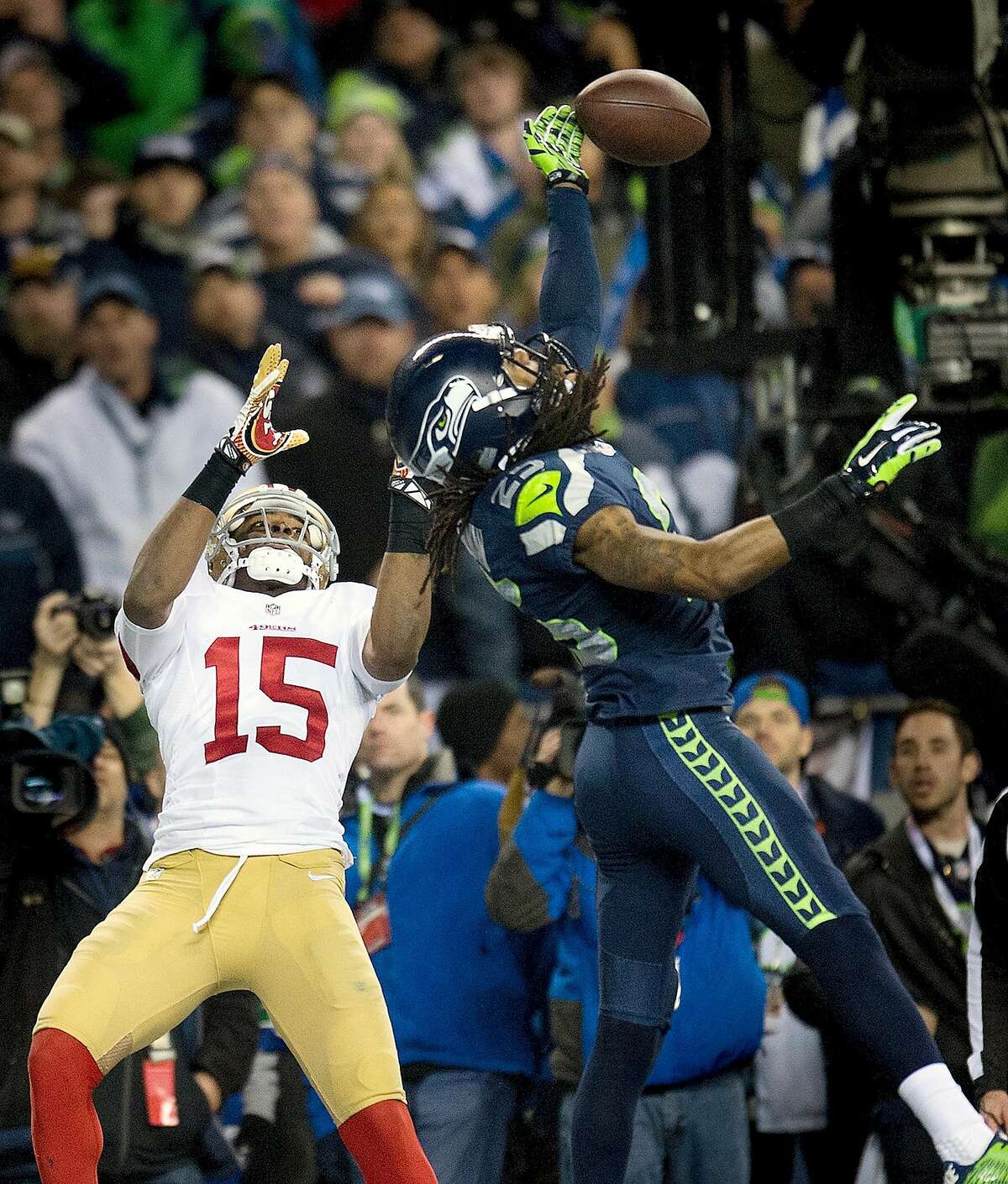 CORRECTS BYLINE TO PAUL KITAGAKI JR.-Seattle Seahawks cornerback Richard Sherman (25) hits the ball away from San Francisco 49ers wide receiver Michael Crabtree (15) and is intercepted by Seattle Seahawks outside linebacker Malcolm Smith (53) during the NFL football NFC Championship game, Sunday, Jan. 19, 2014, in Seattle. The Seahawks won 23-17 to advance to the Super Bowl. (AP Photo/The Sacramento Bee, Paul Kitagaki Jr.) MAGS OUT; TV OUT (KCRA3, KXTV10, KOVR13, KUVS19, KMAZ31, KTXL40) MANDATORY CREDIT