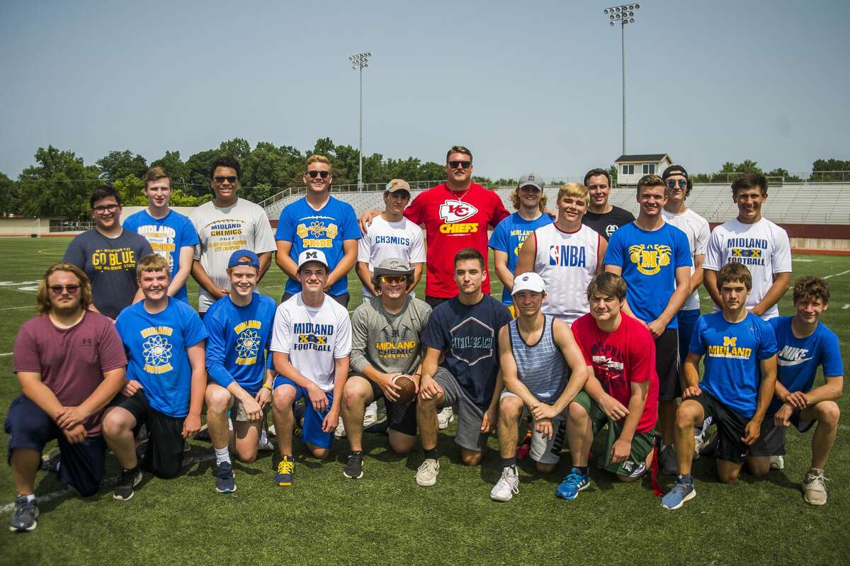 Midland High football players pose for a photo with Andrew Wylie, a Midland High graduate who now plays for the Kansas City Chiefs, during the Midland Chemics free youth football camp on Tuesday, July 9, 2019 at Midland High School. (Katy Kildee/kkildee@mdn.net)