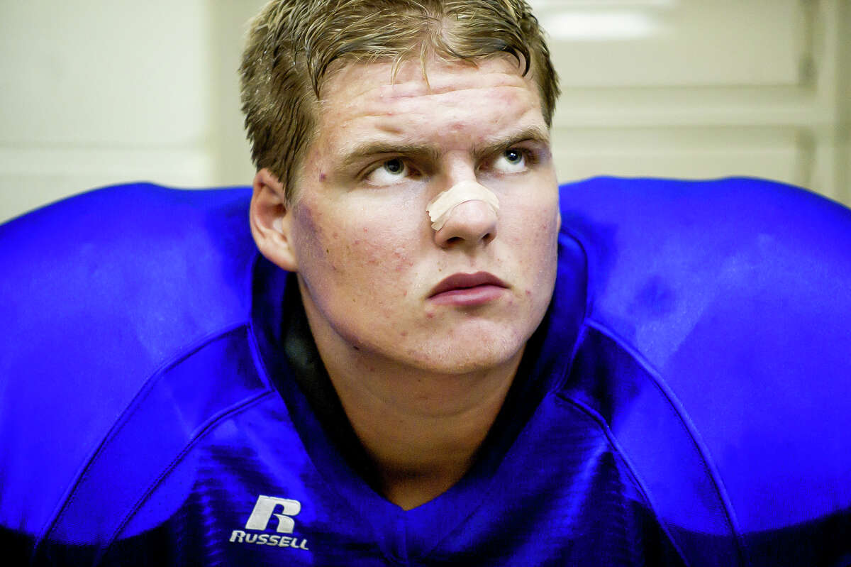 Midland High's Andrew Wylie listens to his coaches in the locker room during a game against Saginaw Heritage in 2011. (Daily News file)