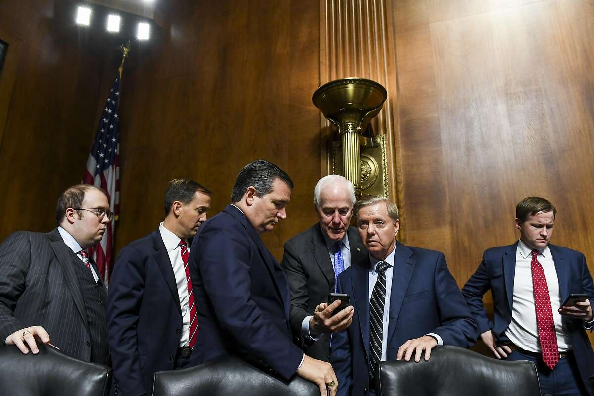 Senator Ted Cruz, a Republican from Texas, shown center left, with Senate Majority Whip John Cornyn, a Republican from Texas, center, and Senator Lindsey Graham, a Republican from South Carolina, in the Senate on Thursday, Sept. 27, 2018. Cruz was one of the Senators who drank milk during this week's impeachment proceedings.