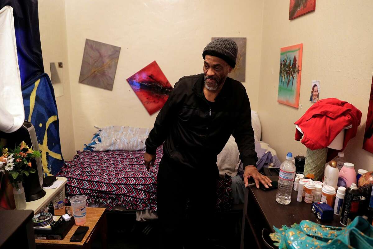 Peter Laimont, left, in his room where he displays artwork by his son at the Henry Robinson Center in Oakland, Calif., on Tuesday, January 14, 2020. Laimont will soon move out of the center into more permanent housing with the help of the Bay Area Community Services and All Home, an organization that seeks to create a Bay Area-wide network for homeless individuals.