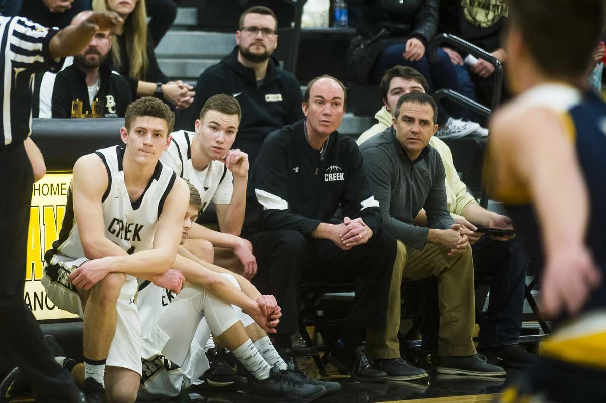 Bullock Creek head coach Doug Bradford, center right, watches from the bench as his son, Seth Bradford, center left, waits to sub into the Lancers' game against Ithaca Friday, Jan. 24, 2020 at Bullock Creek High School. (Katy Kildee/kkildee@mdn.net)