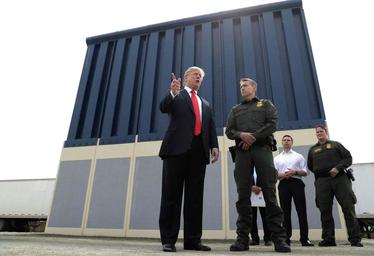 ARCHIVO - En esta fotografía del 13 de marzo de 2018, el presidente Donald Trump habla durante una revisión de los prototipos para el muro fronterizo en San Diego, mientras Rodney Scott, jefe del sector de San Diego de la Patrulla Fronteriza, lo escucha.