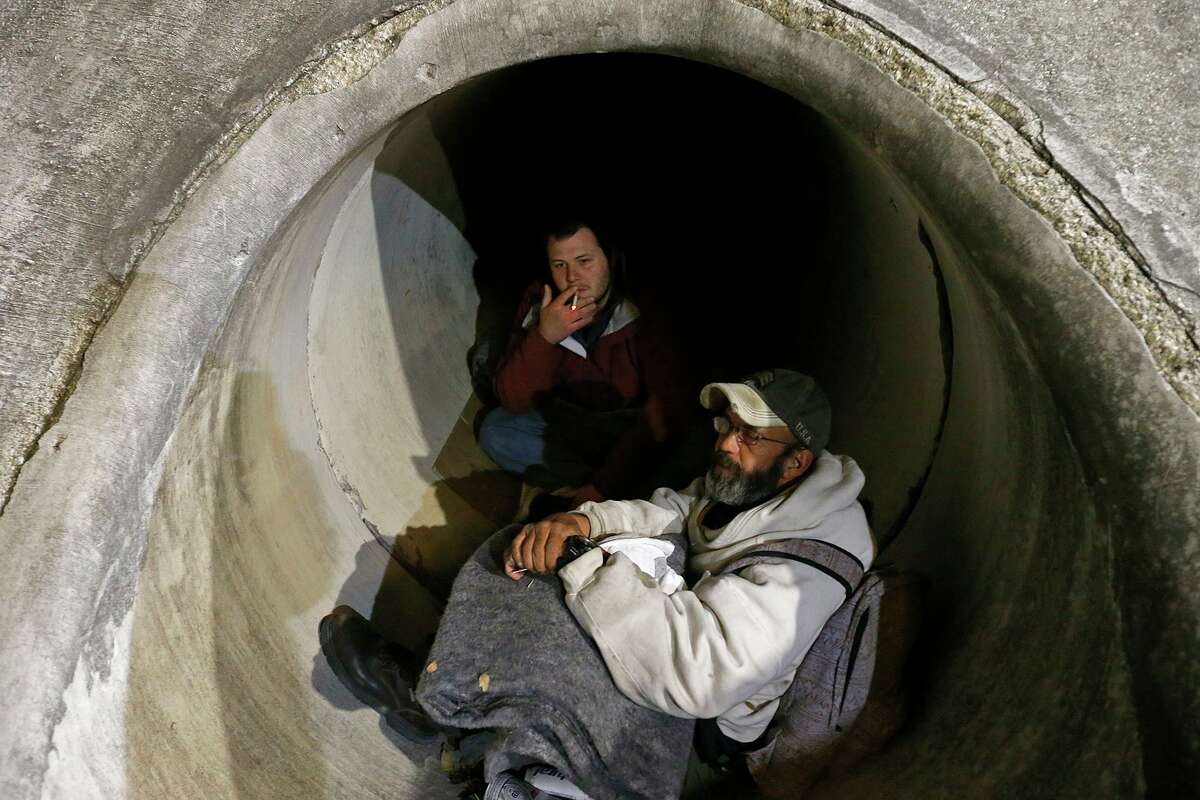 Phillip Kenowitz (left rear), and Marv Mitchel talk about being homeless while trying to stay warm in a drainage tunnel at I-10W and De Zavala Road Thursday Jan. 11, 2018.