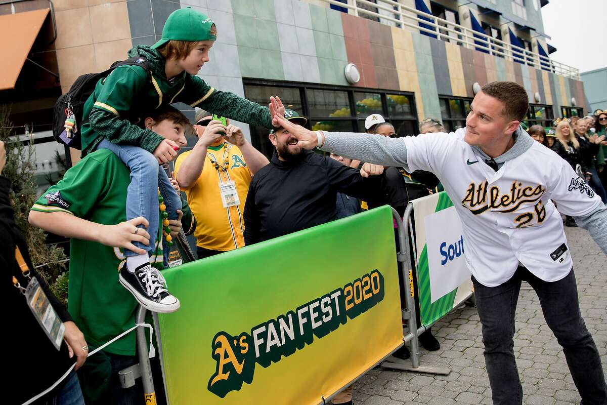 Oakland A's third baseman Matt Chapman high-fives a fan in the crowds during the player's procession kicking off the Oakland A's Fan Fest held at Jack London Square in Oakland, Calif. Saturday, January 25, 2020.