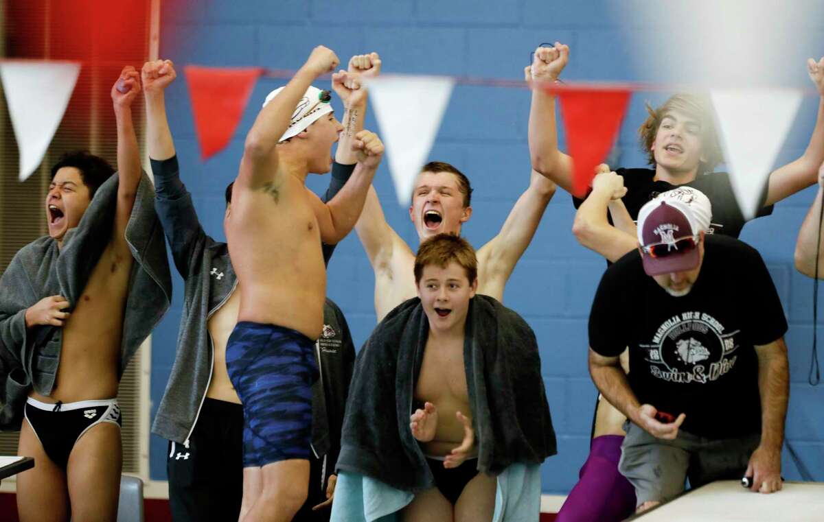 Magnolia swimmers cheer as they compete in the boys 200-yard freestyle relay during the District 21-5A swimming championships at the Tomball ISD Aquatic Center, Saturday, Jan. 25, 2020, in Tomball.