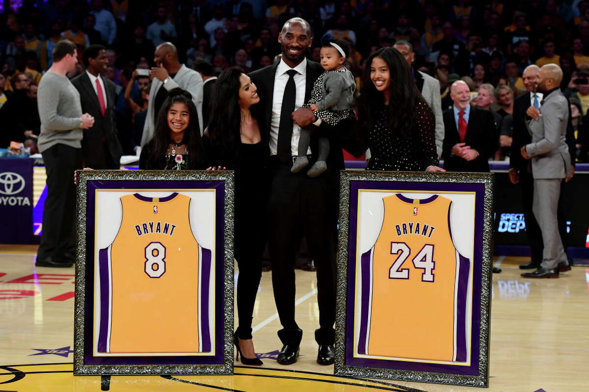 Kobe Bryant poses with his family at halftime after both his #8 and #24 Los Angeles Lakers jerseys are retired at Staples Center on December 18, 2017 in Los Angeles, California.