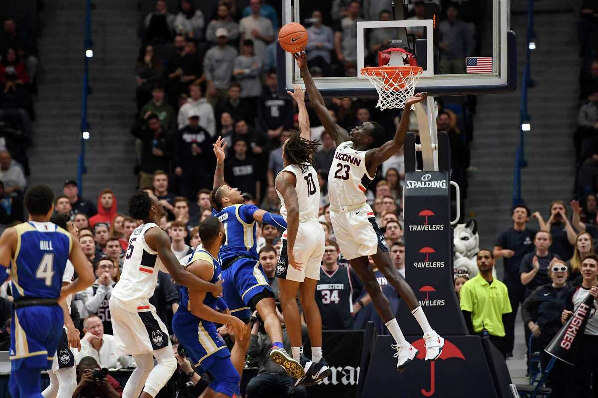 Connecticut's Akok Akok (23) blocks a shot-attempt by Tulsa's Darien Jackson (11) in the second half of an NCAA college basketball game, Sunday, Jan. 26, 2020, in Hartford, Conn. (AP Photo/Jessica Hill)
