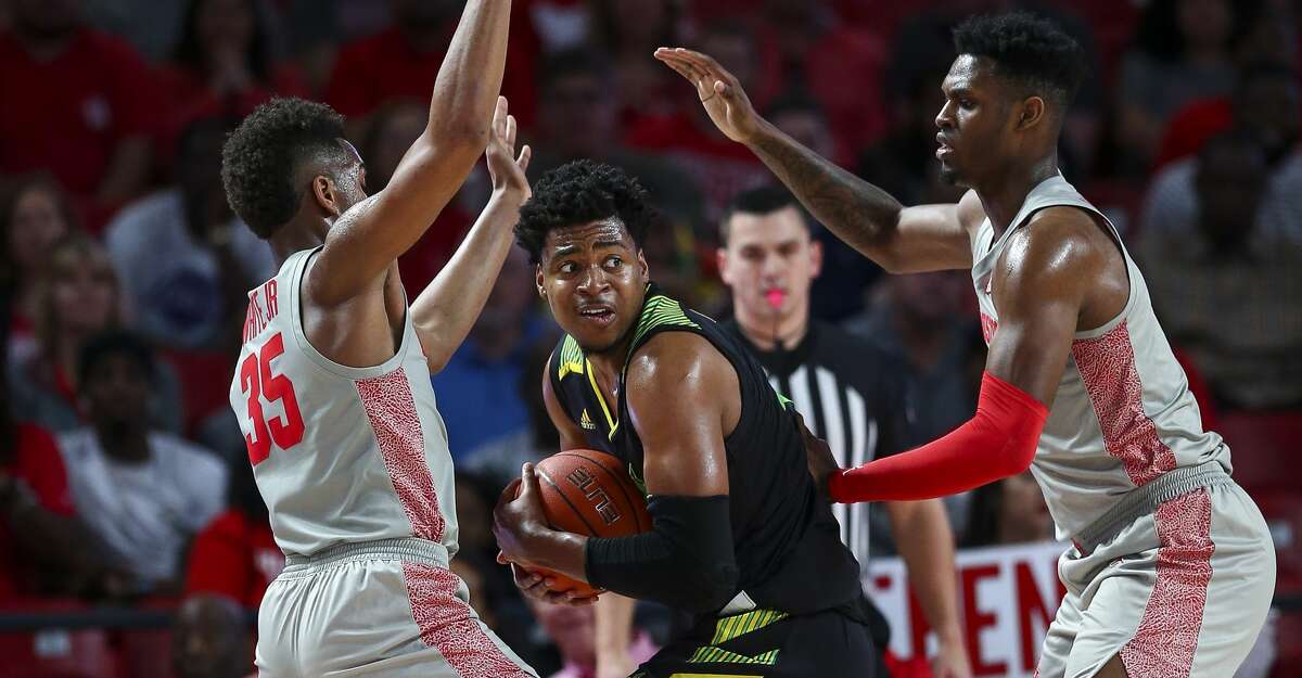 South Florida Bulls forward Michael Durr (4) is defended by Houston Cougars forward Fabian White Jr. (35) and center Chris Harris Jr. (1) during the first half of an NCAA game at the Fertitta Center Sunday, Jan. 26, 2020, in Houston.