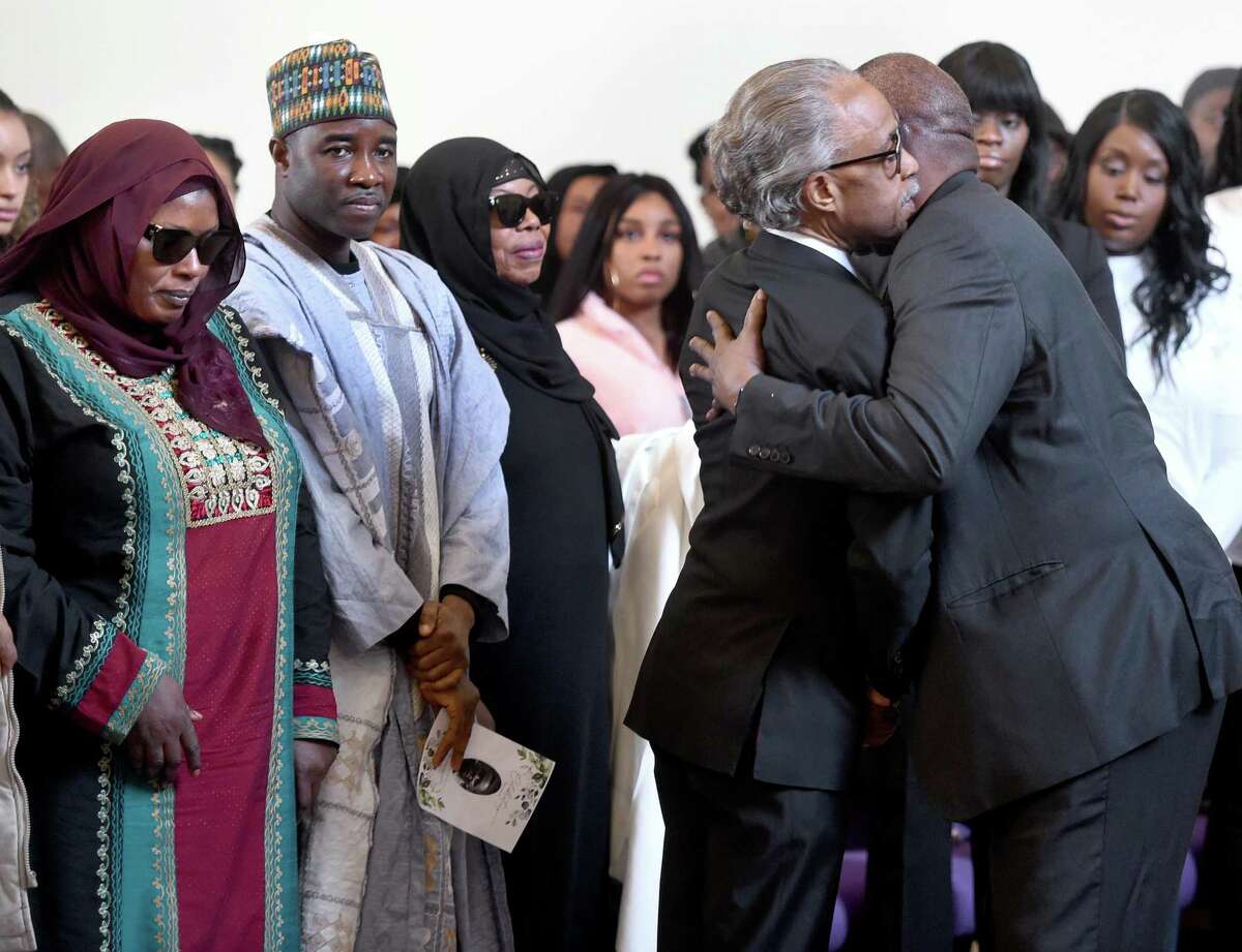 Rev. Al Sharpton (second from right) embraces Suhnoon Adams, great uncle of Mubarak Soulemane, during a memorial service for slain teen at First Calvary Baptist Church in New Haven on January 26, 2020. At far left is Mubarak's mother, Omo Mohammed.