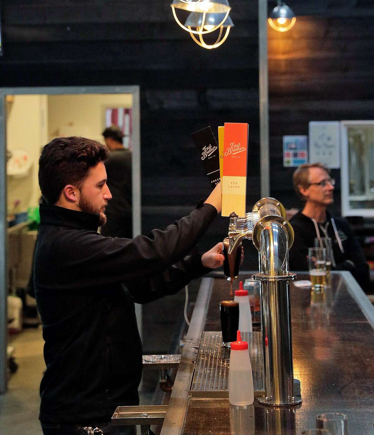 Bartender Gabriel Martin pours a beer behind the bar at East Brother Beer Company which is specializing in craft Lager beer in Richmond, Calif., on Thursday, January 16, 2020. There has been a rise of craft lager beers in the Bay Area, and unlike other local breweries that specialize in hoppy IPAs and sour beers, East Brother Beer Co. in Richmond focuses on classic, balanced lagers.