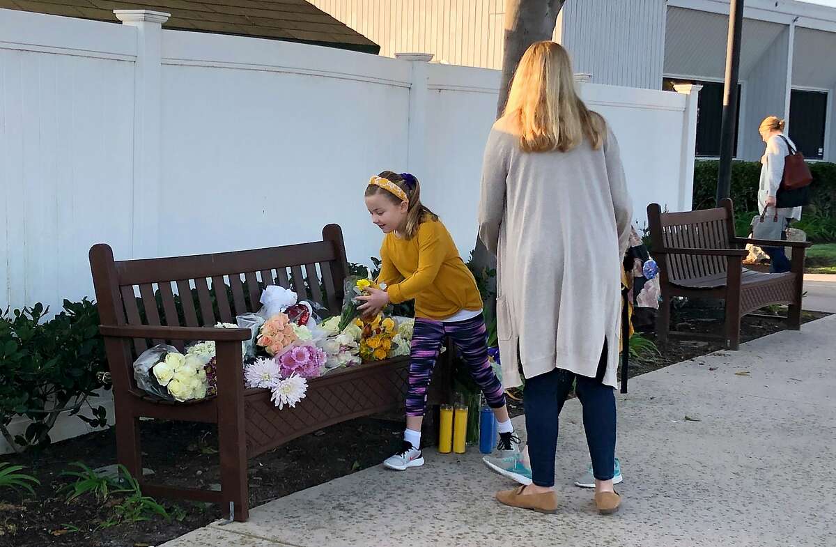 Flowers and messages are placed in front of Harbor Day School, a private elementary school in Corona Del Mar, Calif., Monday, Jan. 27, 2020. Christina Mauser, a girls basketball coach at the school, was among those killed in the helicopter crash that took the lives of former Lakers star Kobe Bryant and seven others Sunday. (AP Photo/Amy Taxin)