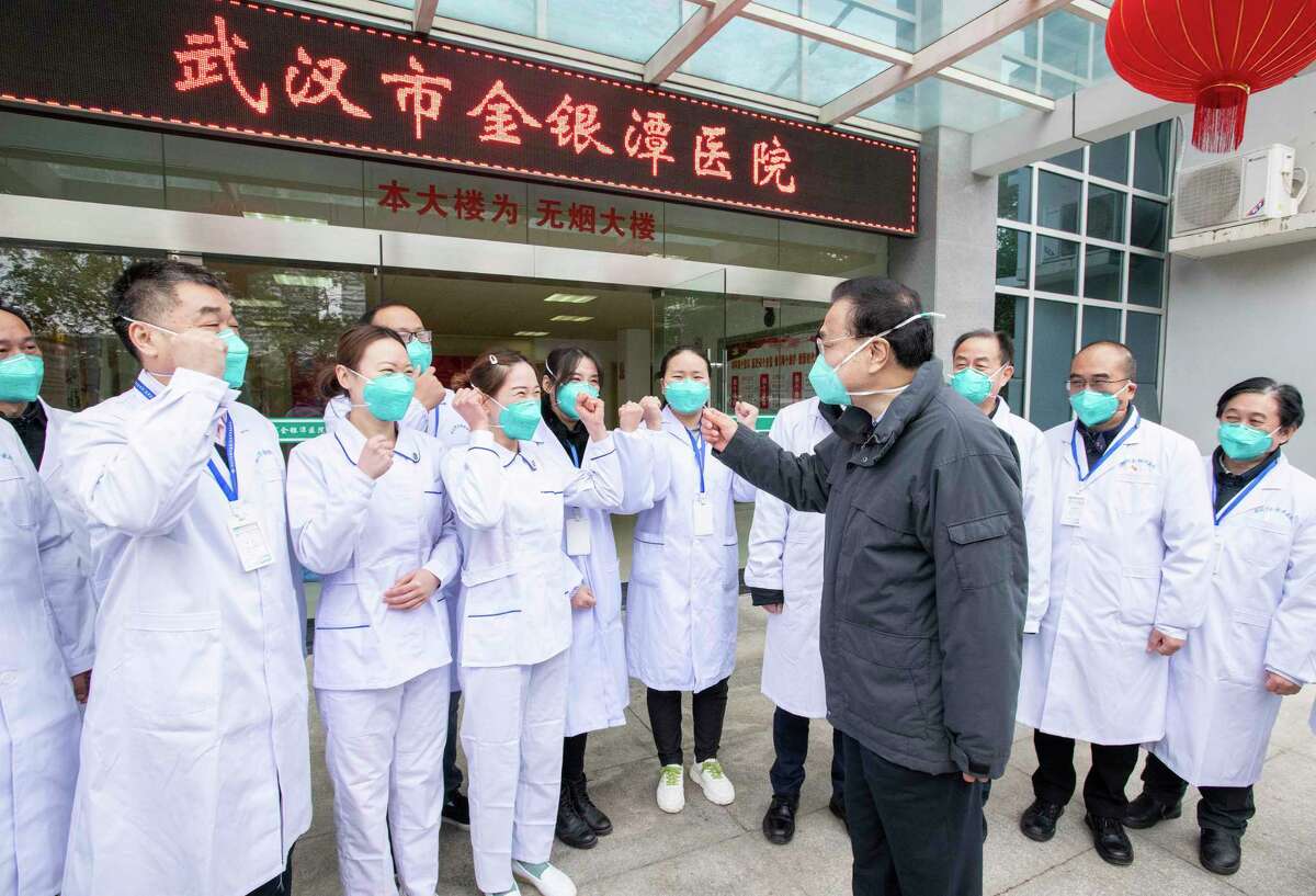 Jan. 27: Chinese Premier Li Keqiang, center, speaks with medical workers at Wuhan Jinyintan Hospital. China expanded its sweeping efforts to contain the deadly virus, extending the Lunar New Year holiday to keep the public at home and avoid spreading infection.