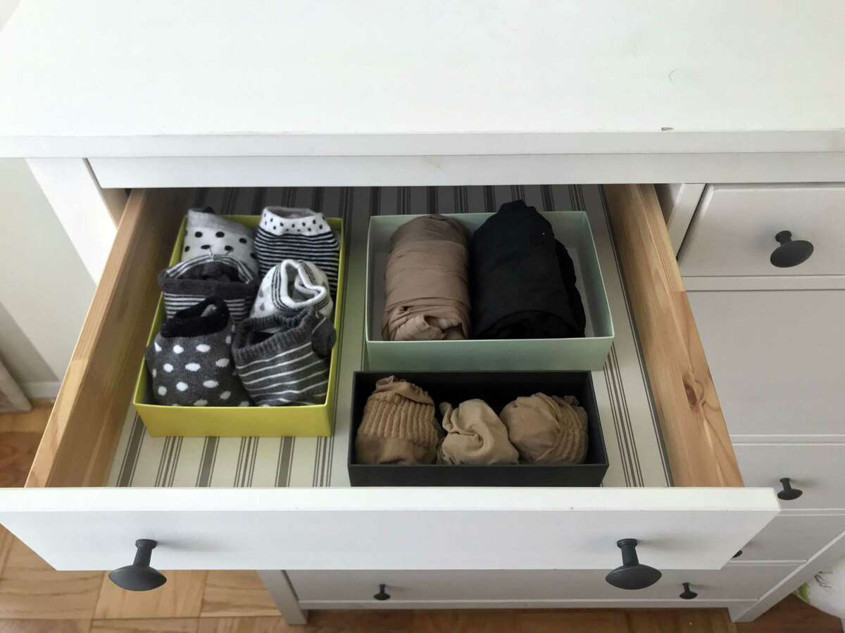 Socks and tights are arranged in a drawer in small boxes, as recommended by Japanese tidying expert Marie Kondo.