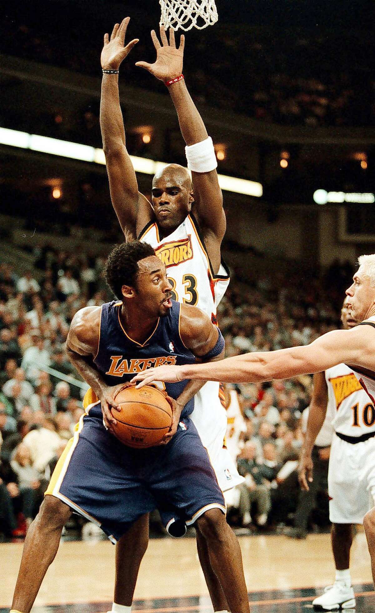 Los Angeles Lakers Kobe Bryant, front, looks for a passing lane through Golden State Warriors defenders Antawn Jamison, top, and Bob Sura, right, during the first period Wednesday, Dec. 6, 2000 in Oakland, Calif. Bryant and Jamison scored 51 points apiece, the first NBA game since 1962 to feature two 50-point scorers. (AP Photo/Oakland Tribune, D. Ross Cameron)