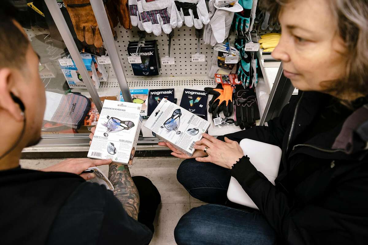 Store manager Renato Geslani, left, helps customer Frances Mocnik, who is flying back to her native Sydney, Australia, shop for reusable N95 masks at the downtown Cole Hardware in San Francisco, Calif, on Tuesday, January 28, 2020.