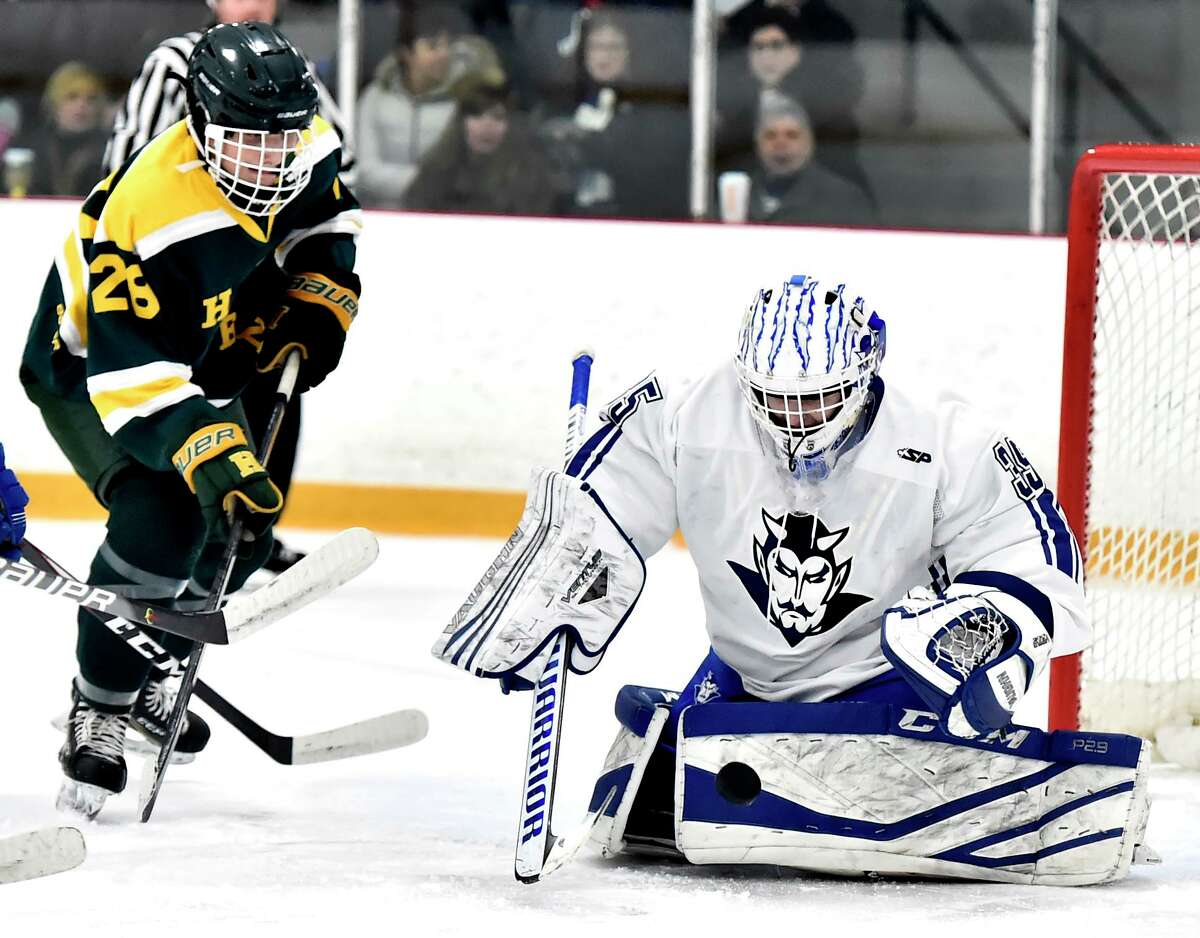Hamden’s, left, watches the puck bounce off of West Haven goalie Jared Pliszka during a game earlier this season.