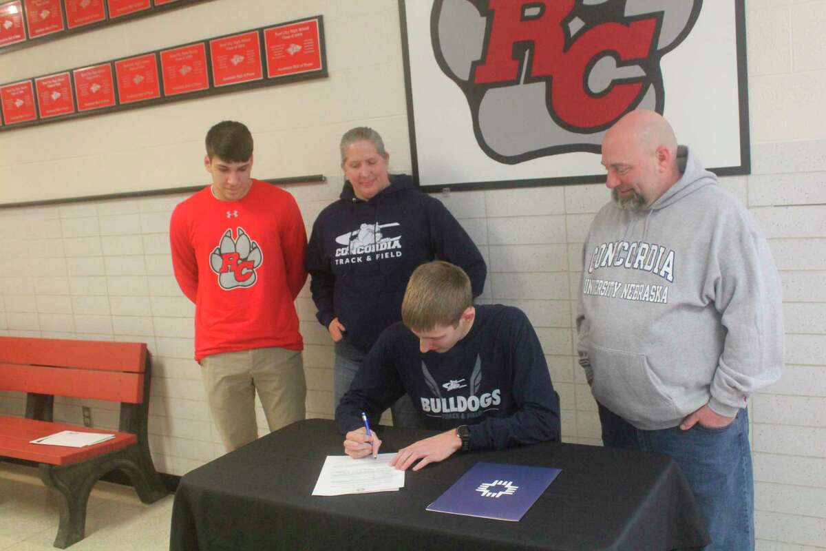 Reed City's Calvin Rohde signs his letter of intent with Concordia University of Nebraska on Thursday, surrounded by his parents, Grant and Laura Rohde, and his brother, Aaron Rohde. (Herald Review photo/John Raffel)