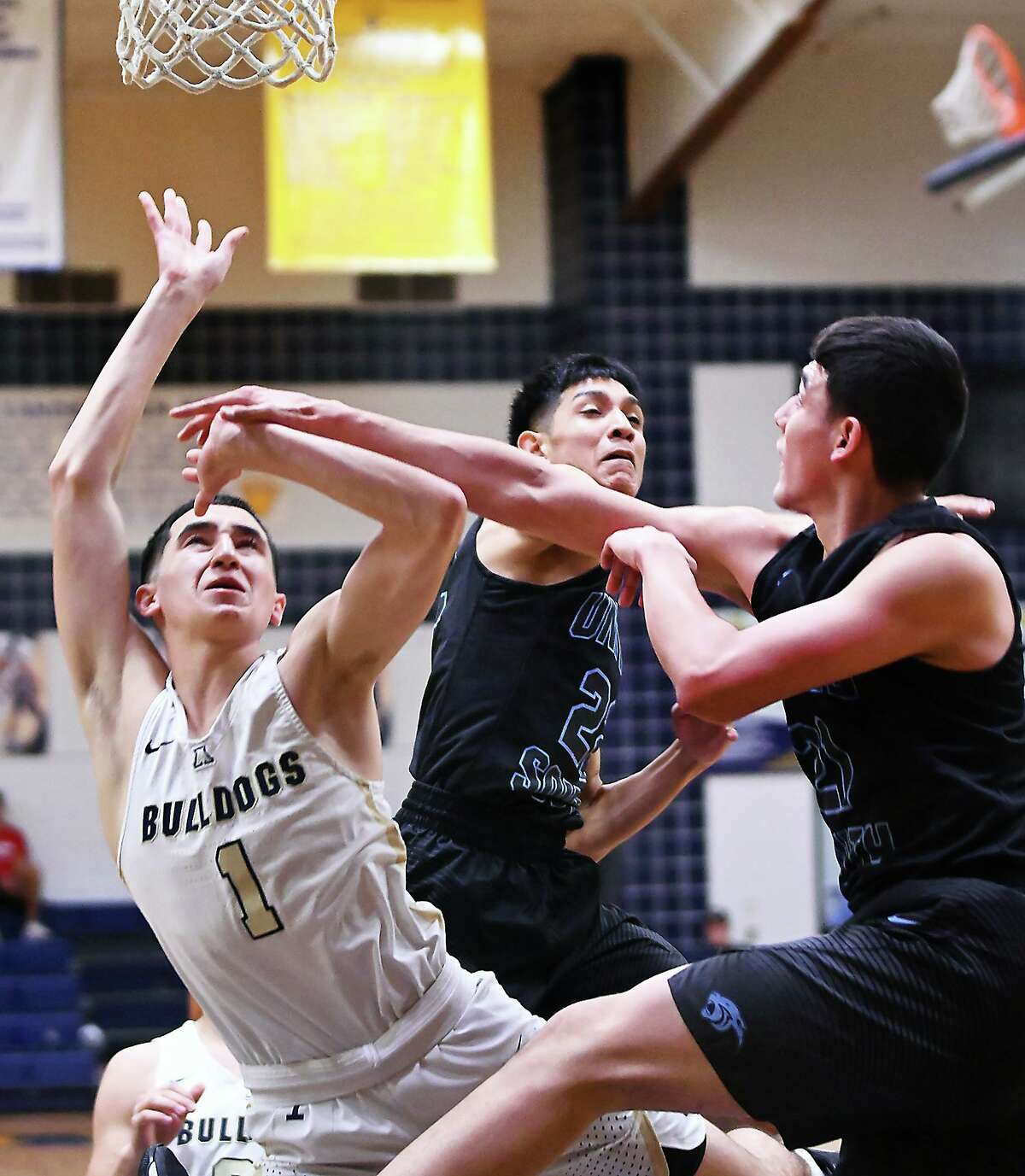 Adrian Orozco drives to the basket for the Alexander Bulldogs as AJ Cisneros and Andy Cisneros defend for the Panthers Tuesday, January 28, 2020 at the Alexander Gym.